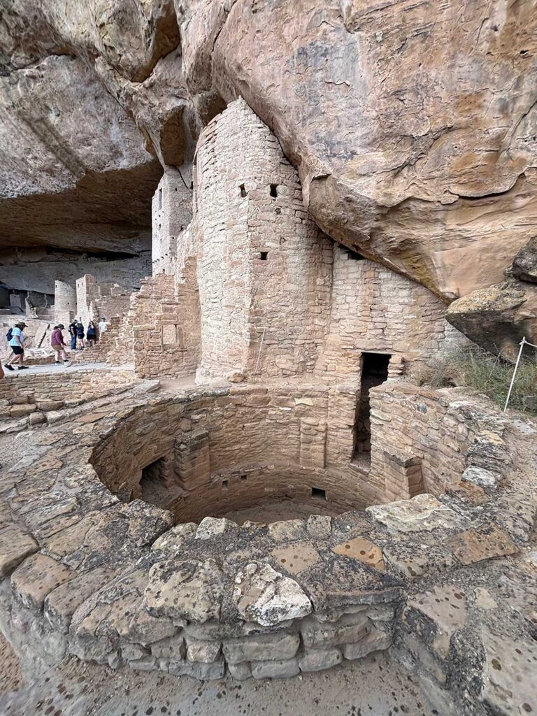 View of a circular kiva from above, showing the interior wall, niches, and depth of the space below.