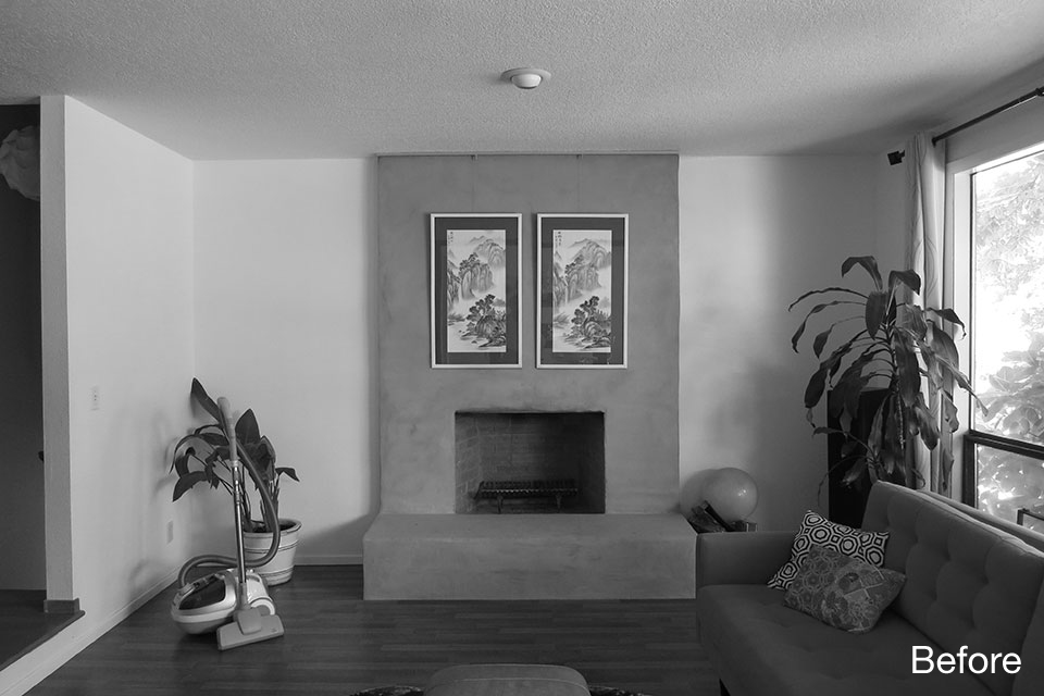 Existing living room with fireplace and limited connection to adjacent spaces prior to renovation.
