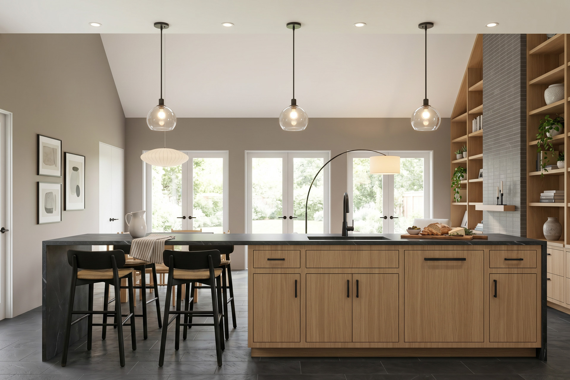 Kitchen with light wood cabinetry, dark stone countertops, large island with bar seating, pendant lights, and French doors opening to the garden.